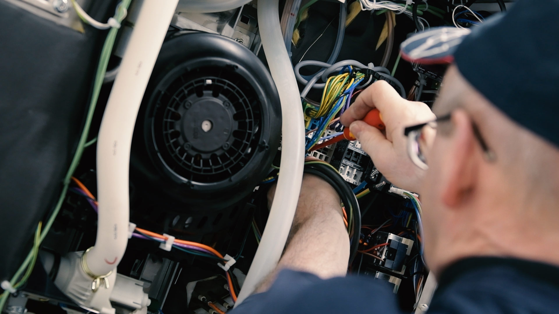 Ein Handwerker repariert eine Maschine, indem er mit einem Schraubenzieher arbeitet